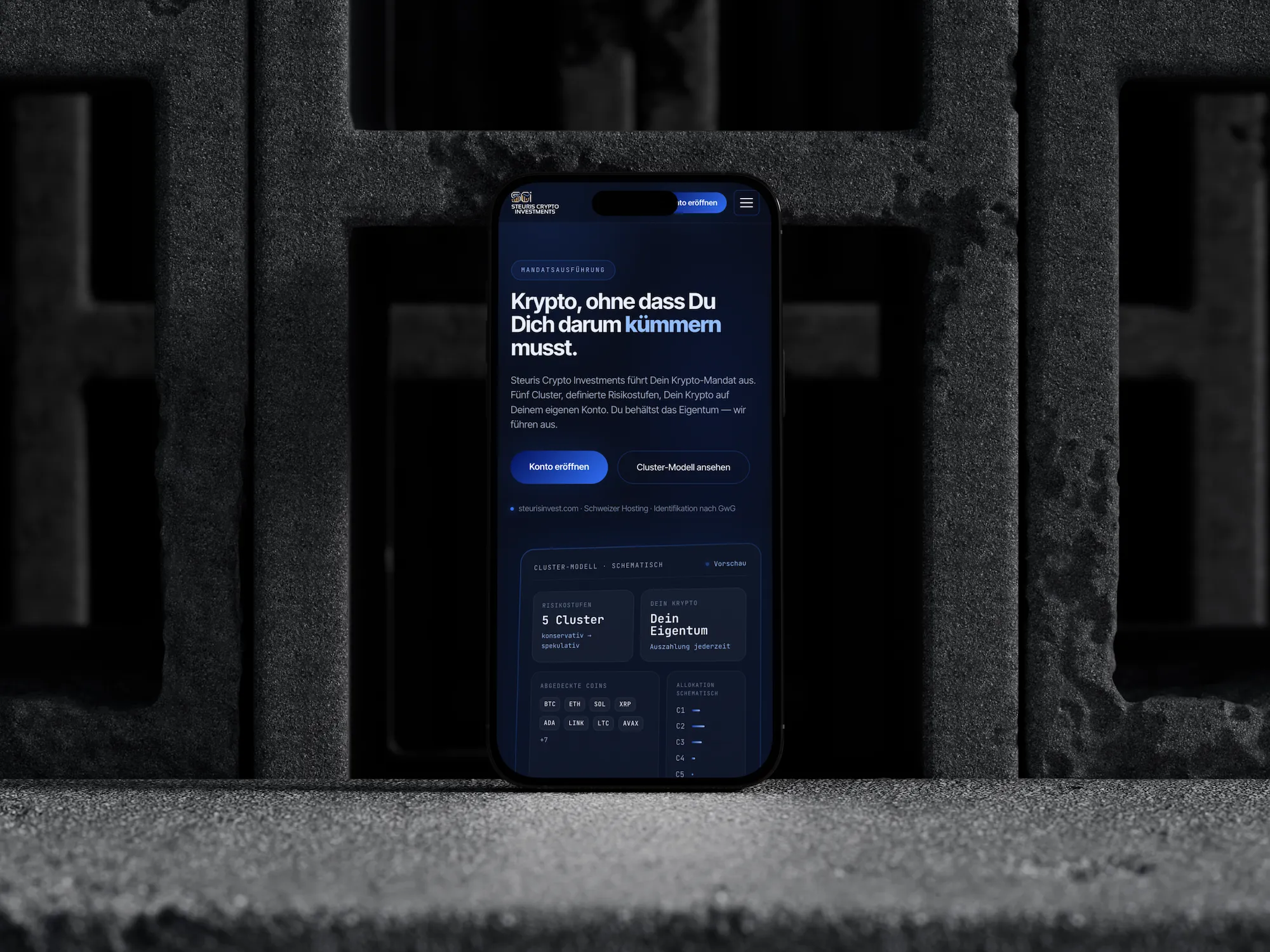Die Startseite von Steuris Crypto Investments auf einem iPhone, aufgestellt vor Betonblöcken